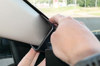 Montering av en surfplatta i ett fäste på bilens instrumentbräda.